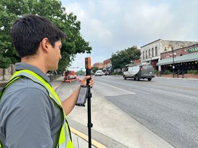 Field technician using a Bad Elf Flex Mini on a monopod